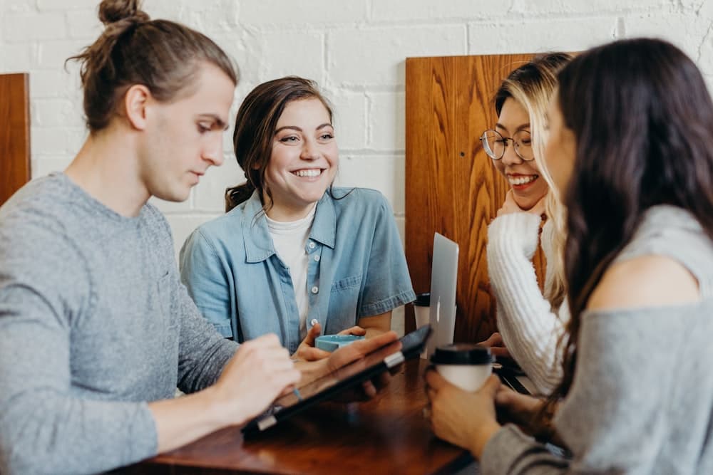 People relaxed and smiling together over coffee, free from bill stress